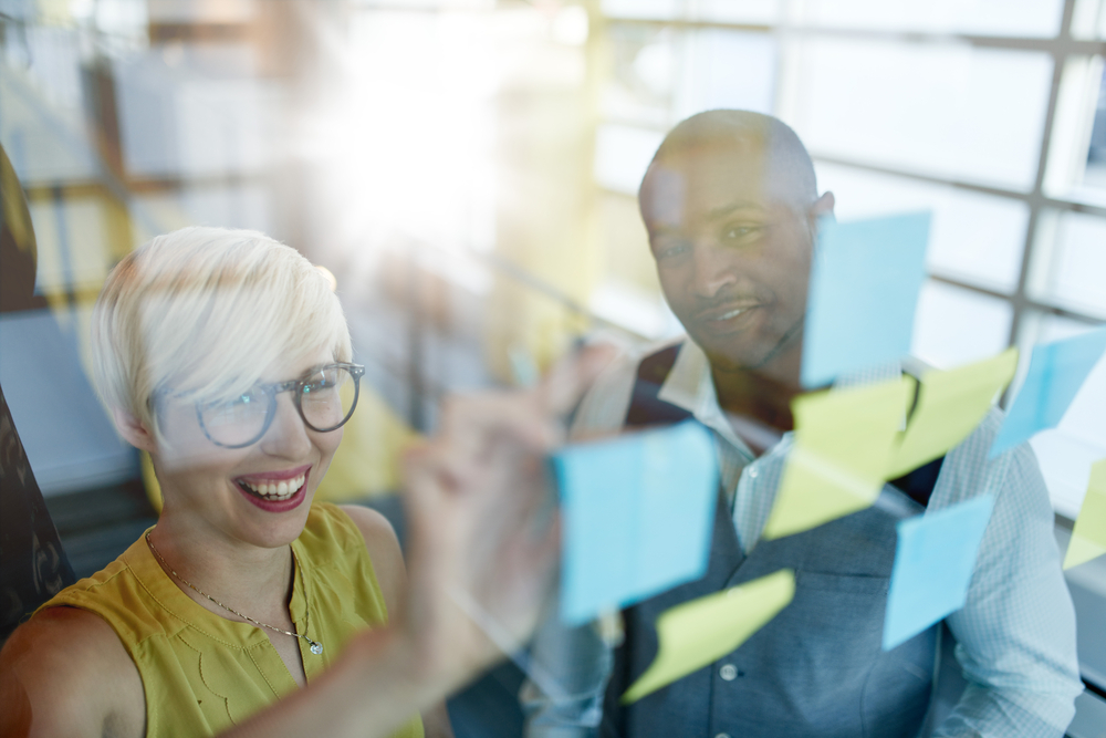 Two team members plan a property management marketing strategy. 